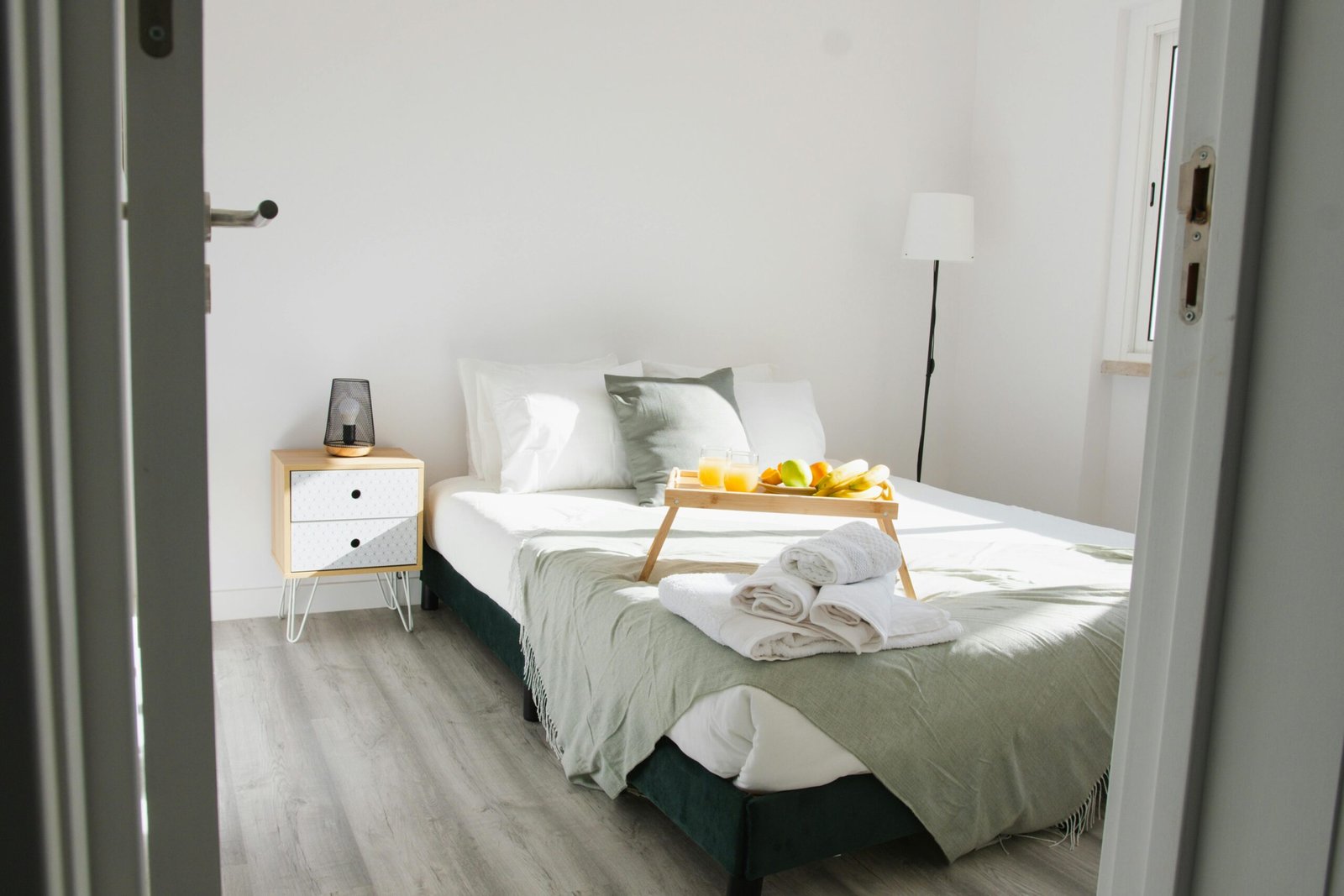 Nos Services Inviting bedroom interior featuring a comfortable bed with a breakfast tray and stylish decor.